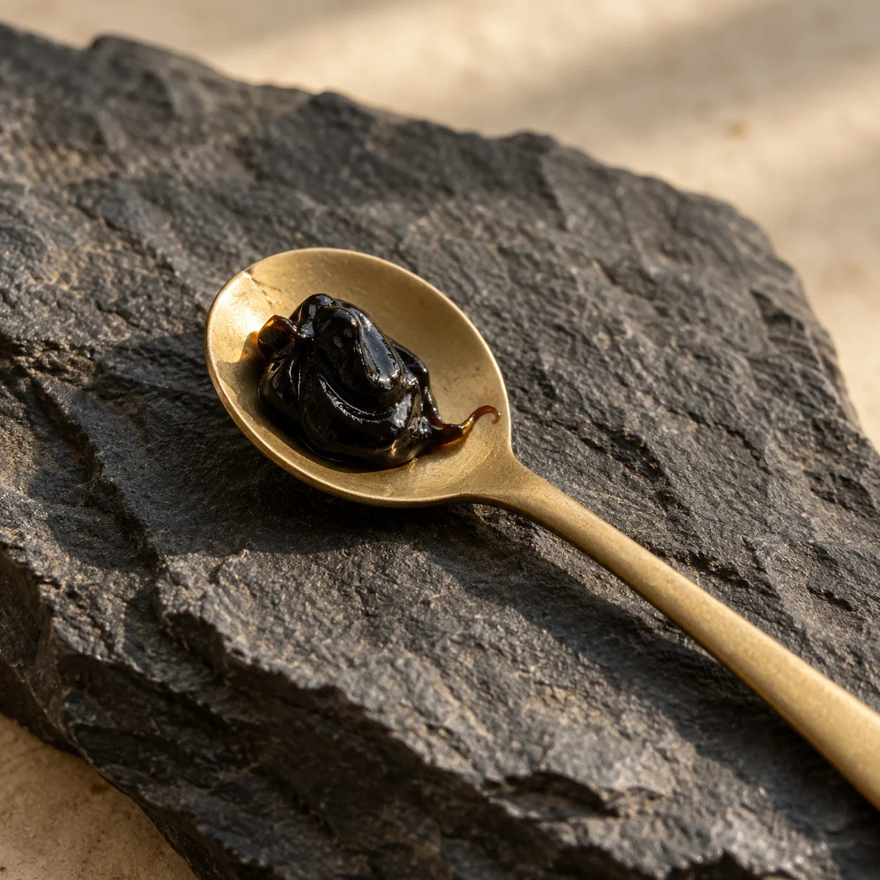 Glossy resin on a brass spoon over Himalayan slate